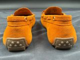 pair of orange sued moccali shoes with studded soles