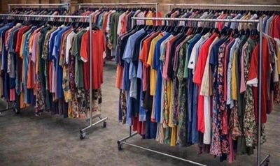 beaucoup de vêtements suspendus à une étagère dans une pièce