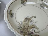 a plate with a fern design on it sitting on a table