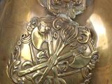 a gold colored vase with a decorative design on it