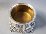 a silver cup sitting on top of a silver stand