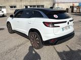 a white car parked in a parking lot next to a building