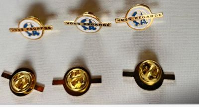 three gold and silver cuff rings with a blue and white logo