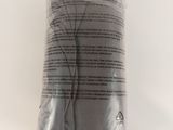 un sac en tissu gris posé sur une surface blanche