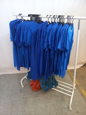 un portant sur lequel sont suspendues plusieurs chemises bleues