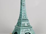 une tour Eiffel en céramique verte surmontée d'une bougie