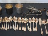 a lot of silver spoons and silverware on a table