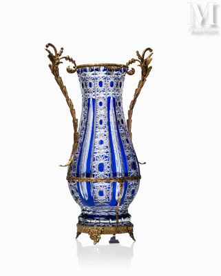un vase bleu et blanc posé sur un socle, sur une surface blanche