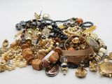 a pile of assorted jewelry on a white surface