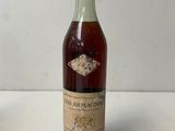 an old bottle of wine sitting on top of a white table