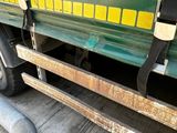 a green truck with yellow stripes parked on the side of the road