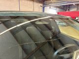 a car that has a broken windshield in a garage