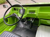 a green truck with a steering wheel and dashboard