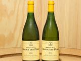 deux bouteilles de vin posées sur un tonneau en bois