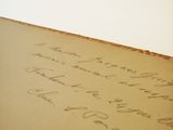 an old book with writing on it sitting on top of a table
