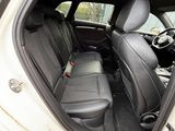 the back seats of a car with the door open in a parking lot