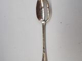 a silver spoon with a spoon handle on a white surface