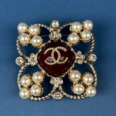 a close up of a brooch with pearls and pearls