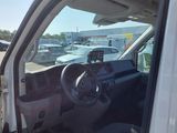 a white van with the driver ' s seat down in a parking lot