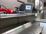 une étagère en métal sur laquelle est posé un seau, dans une cuisine