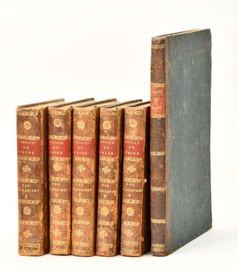 several old books are lined up in a row on a white surface
