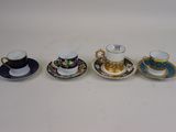 quatre tasses et soucoupes sont alignées sur une surface blanche