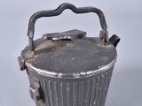a small metal pot with a handle on a white surface