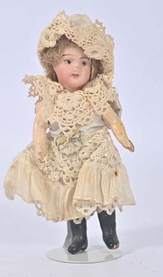 a small doll that is wearing a dress and hat