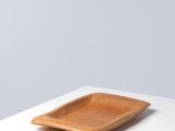 the square wooden plate is sitting on a white table