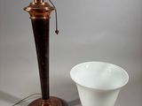 an antique copper plated lamp with a white bowl next to it
