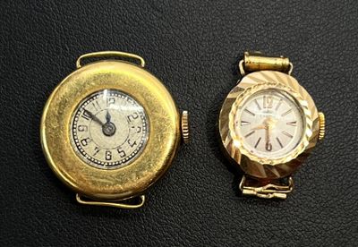 two watches sitting next to each other on a black surface