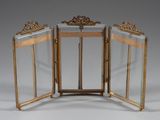 two gold - plated folding mirrors with ornate designs on the sides