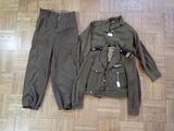 a jacket and pants on the floor next to a pair of shoes