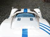 a white and blue race car parked on a cobblestone street