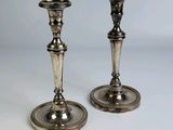 deux bougeoirs en argent posés sur une table