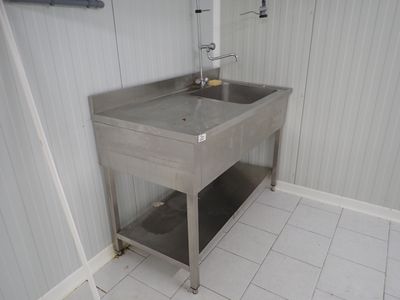 un évier en acier inoxydable dans le coin d'une salle de bains