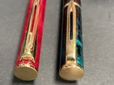 two pens sitting next to each other on a table