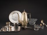 un plateau en argent et des couverts en argent posés sur une table noire