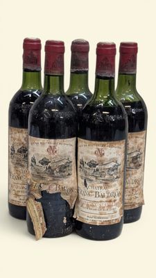 quatre bouteilles de vin sont alignées sur une surface blanche
