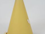 a yellow cone shaped lamp that is on a table