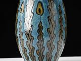 a blue and yellow vase sitting on a white table