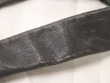 a close up of a black leather belt on a white shirt