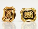 paire de boucles d'oreilles dorées et émaillées de noir, rehaussées de touches dorées