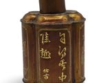 une image représentant un pot de couleur marron et doré sur lequel figure une inscription