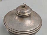 silver plated teapot with lid on a table next to a teapot