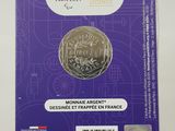 a close up of a purple card with a coin on it