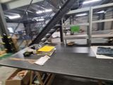 a long table with a laptop on it in a warehouse