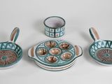 five pieces of pottery sitting on a white surface