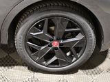 a close up of a black car with a red emblem on it