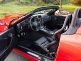 a red sports car with its doors open in the driveway